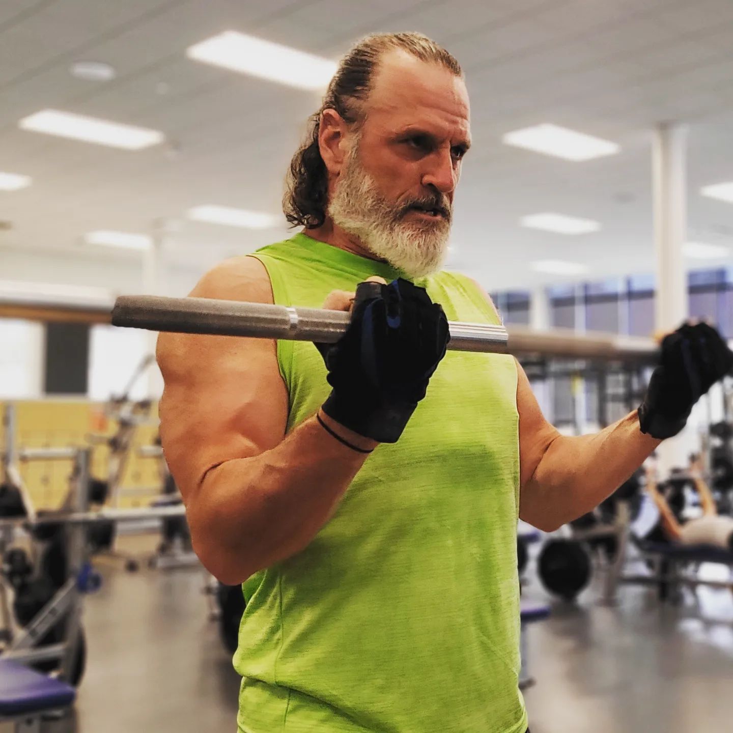 John Larson performing a barbell curl at Life Time Fitness in St. Louis